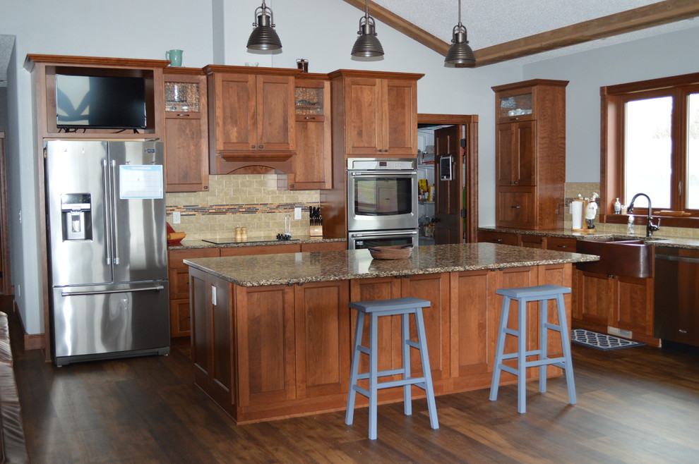 Example of a mid-sized transitional l-shaped kitchen design with a farmhouse sink, shaker cabinets, medium tone wood cabinets, quartzite countertops, beige backsplash, stainless steel appliances and an island