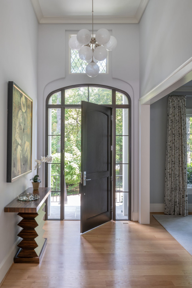 ワシントンD.C.にあるラグジュアリーな巨大なシャビーシック調のおしゃれな玄関ロビー (グレーの壁、無垢フローリング、濃色木目調のドア、三角天井) の写真