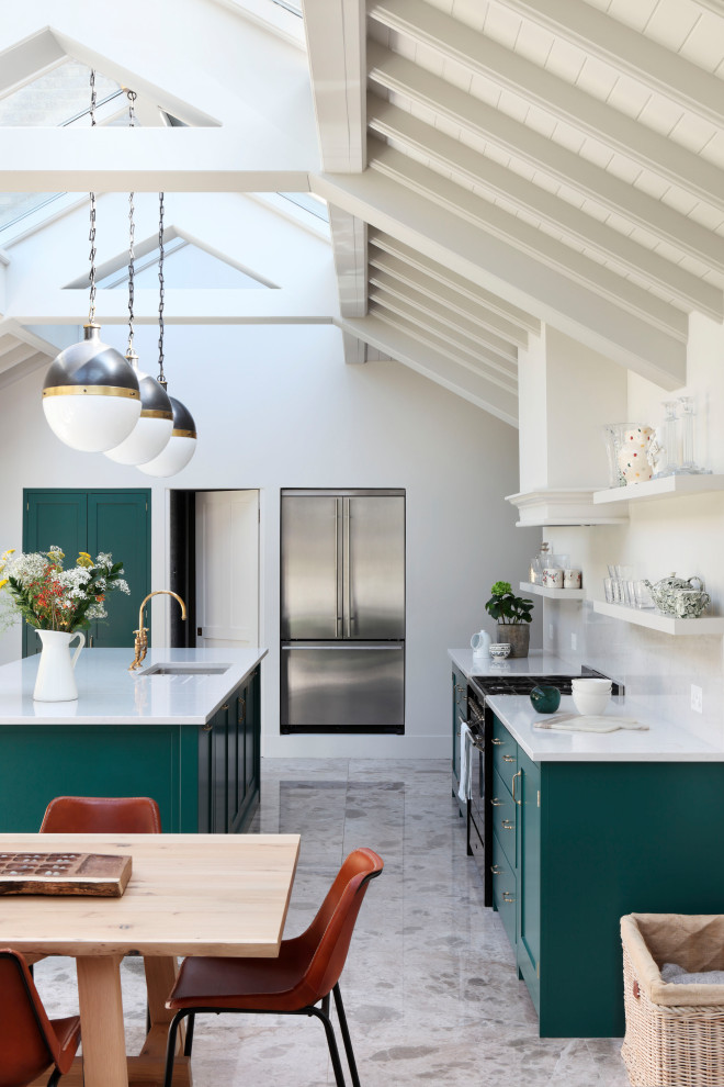 Inspiration for a transitional galley kitchen in London with an undermount sink, shaker cabinets, green cabinets, stainless steel appliances, with island, grey floor and white benchtop.