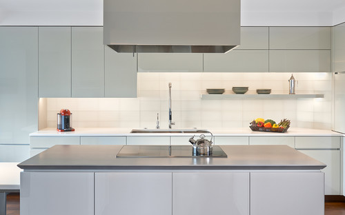 Minimal modern kitchen with seamless flat-front RTA cabinets, island cooktop, and even reveals—showing a clean, level installation with integrated lighting