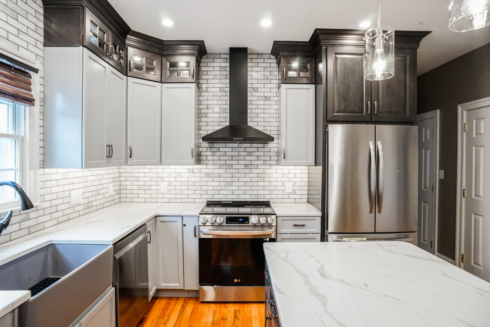 Inspiration for a traditional kitchen in Philadelphia with raised-panel cabinets, grey cabinets, engineered stone countertops, mosaic tiled splashback, light hardwood flooring, an island, orange floors and white worktops.