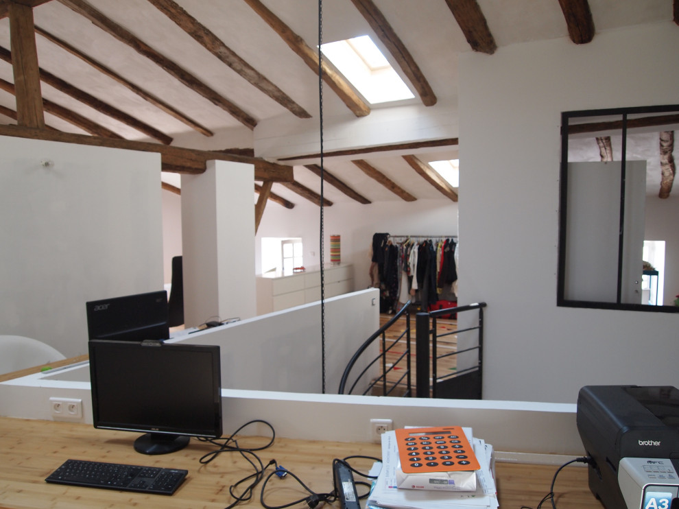 Modelo de despacho actual grande con paredes blancas y suelo de madera pintada