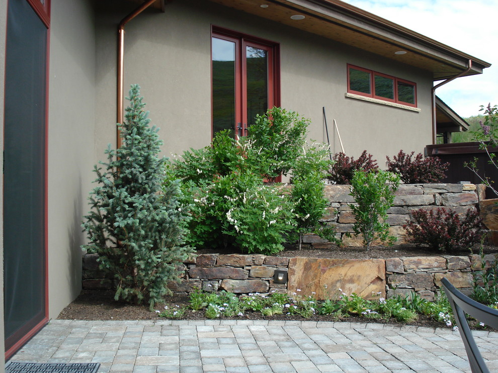 Small traditional backyard full sun formal garden in Boise with a fire feature and natural stone pavers for spring.