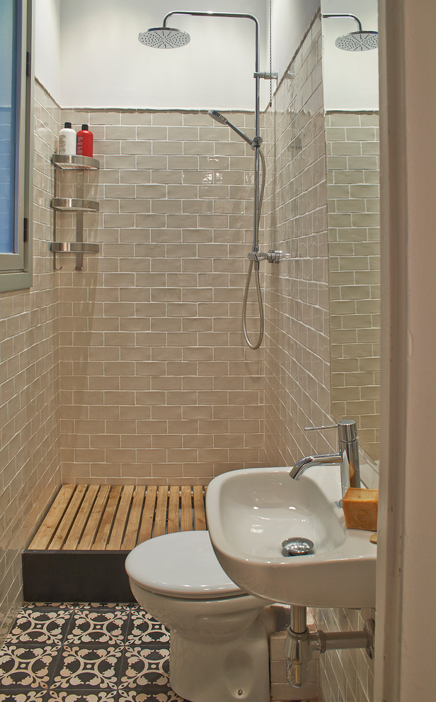 This is an example of a mid-sized mediterranean 3/4 bathroom in Barcelona with an open shower, a two-piece toilet, white walls and a wall-mount sink.