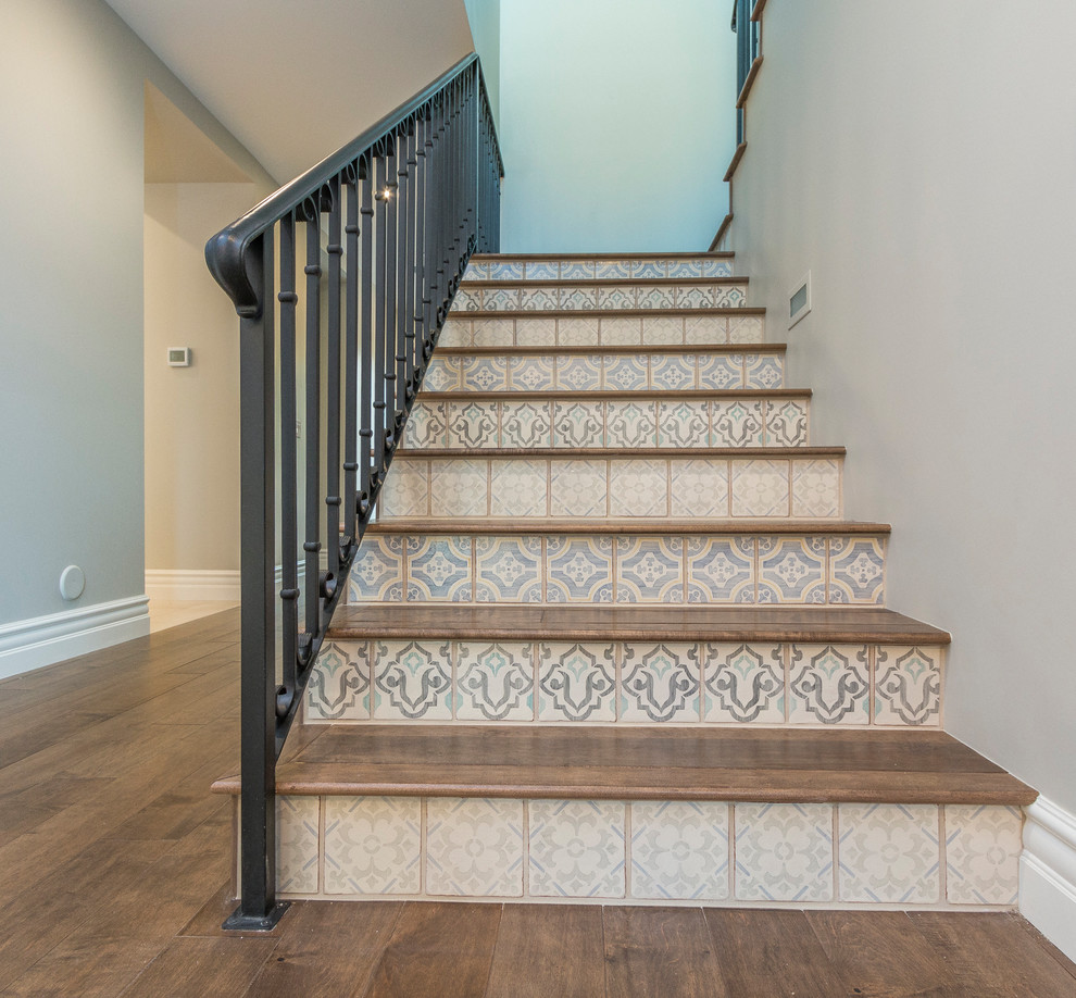 Inspiration for a huge transitional medium tone wood floor and brown floor staircase remodel in Phoenix with gray walls and a metal front door