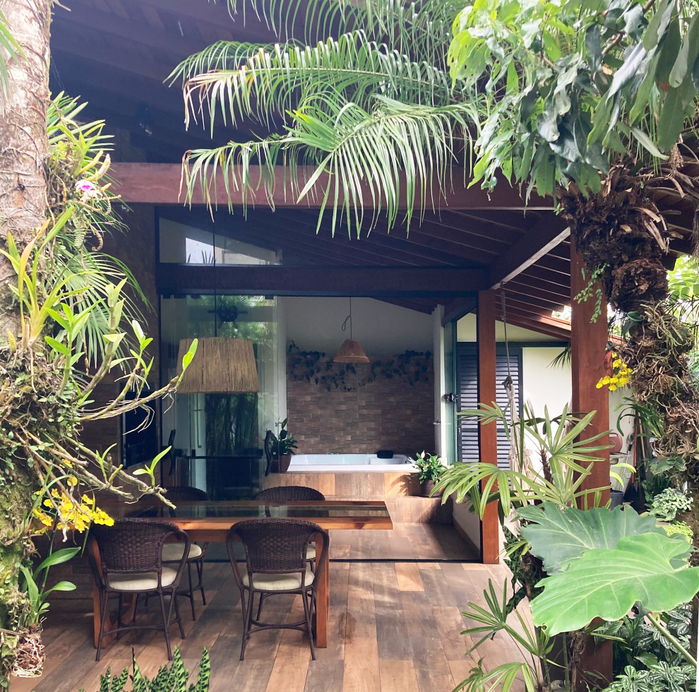 Foto de terraza tropical pequeña en patio trasero y anexo de casas con suelo de baldosas