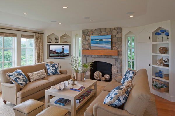 Inspiration for a large beach style enclosed family room in Boston with beige walls, medium hardwood floors, a standard fireplace, a stone fireplace surround, a built-in media wall and beige floor.