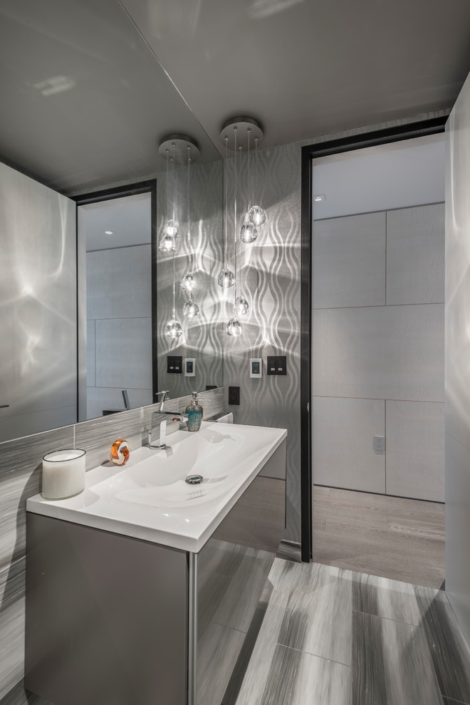 Design ideas for a small contemporary powder room in San Francisco with flat-panel cabinets, grey cabinets, gray tile, porcelain tile, porcelain floors, an integrated sink, engineered quartz benchtops, grey floor and grey walls.