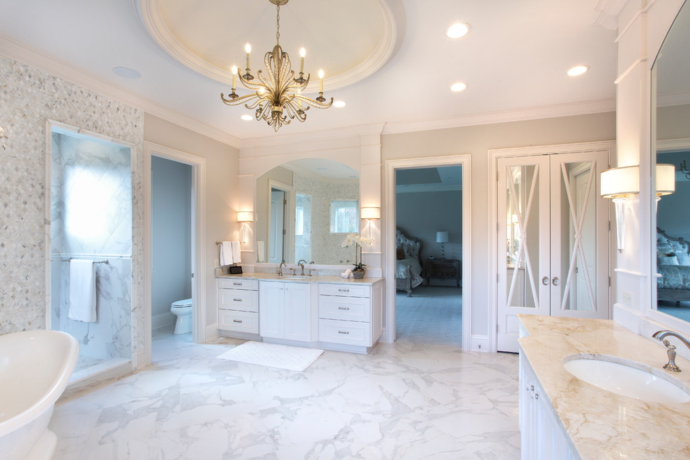 Photo of an expansive traditional master bathroom in Cleveland with beaded inset cabinets, white cabinets, a freestanding tub, a double shower, gray tile, mirror tile, grey walls, marble floors, an undermount sink, engineered quartz benchtops, white floor and an open shower.