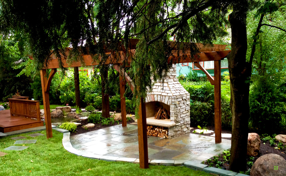 Inspiration for a mid-sized transitional backyard patio in Chicago with a fire feature, natural stone pavers and a pergola.