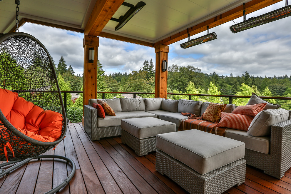 Example of a large minimalist backyard deck design in Seattle with a roof extension