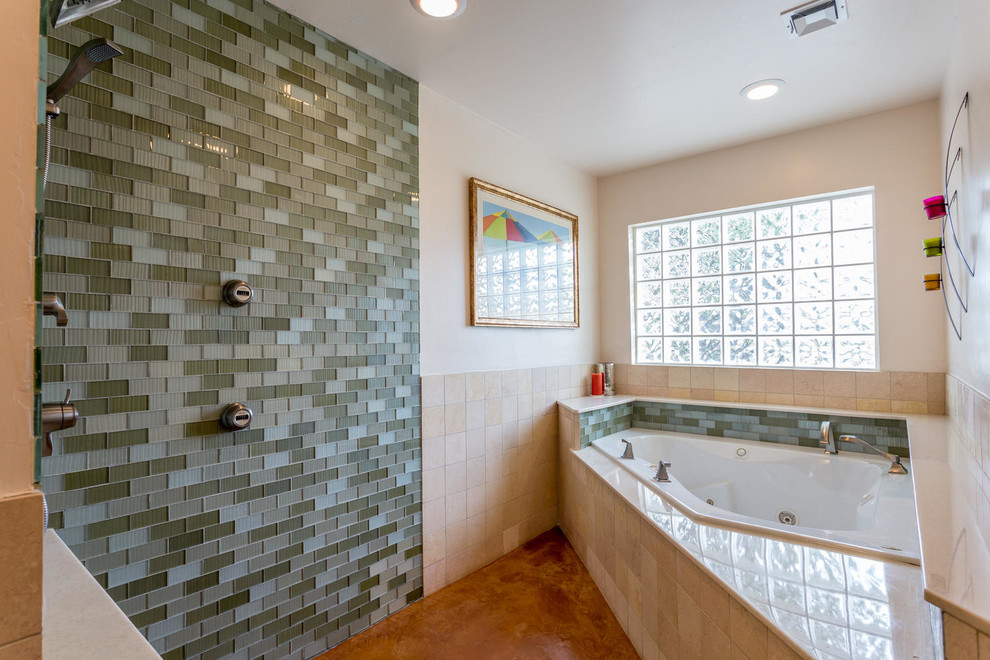 This is an example of a mid-sized modern master bathroom in Las Vegas with an integrated sink, shaker cabinets, medium wood cabinets, engineered quartz benchtops, a corner tub, an open shower, a one-piece toilet, green tile, glass tile, white walls and concrete floors.