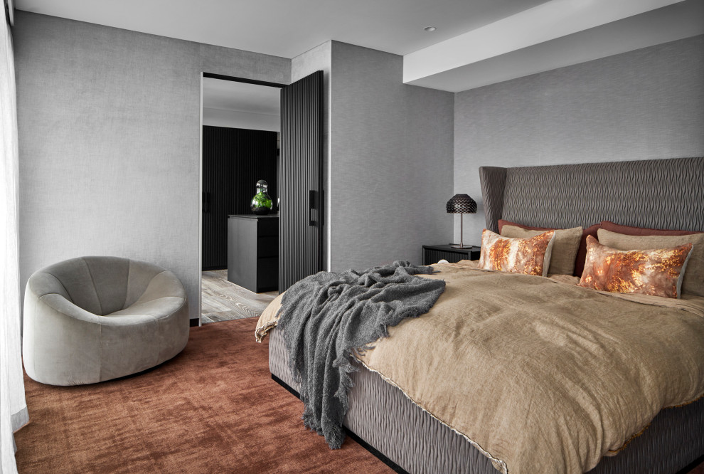 Contemporary master bedroom in Melbourne with grey walls, carpet, orange floor and wallpaper.