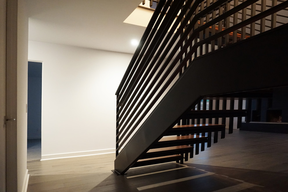 Photo of a large contemporary wood floating staircase in San Diego with open risers.