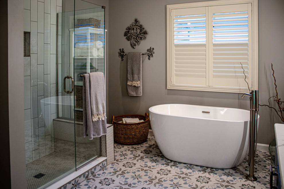Пример оригинального дизайна: главная ванная комната среднего размера в морском стиле с фасадами с выступающей филенкой, отдельно стоящей ванной, душем в нише, раздельным унитазом, белой плиткой, керамической плиткой, серыми стенами, полом из керамической плитки, врезной раковиной, столешницей из гранита, синим полом, душем с распашными дверями, белой столешницей, нишей, тумбой под две раковины и встроенной тумбой