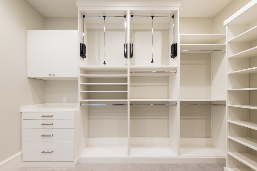 This is an example of an expansive traditional gender-neutral dressing room in Salt Lake City with flat-panel cabinets, white cabinets, carpet and white floor.