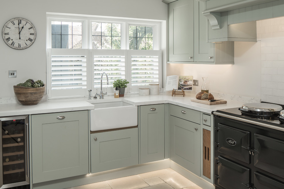 Design ideas for a country kitchen in London with a farmhouse sink, shaker cabinets, green cabinets, white splashback and subway tile splashback.