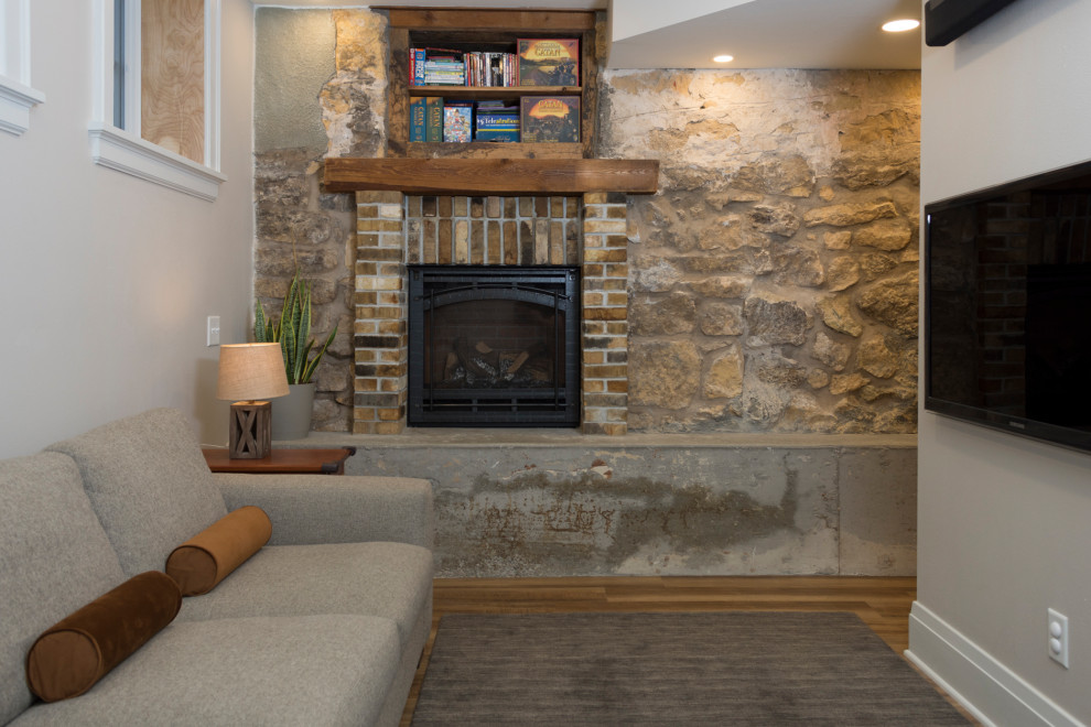 Design ideas for a small transitional look-out basement in Other with white walls, light hardwood floors, a standard fireplace, a brick fireplace surround and beige floor.