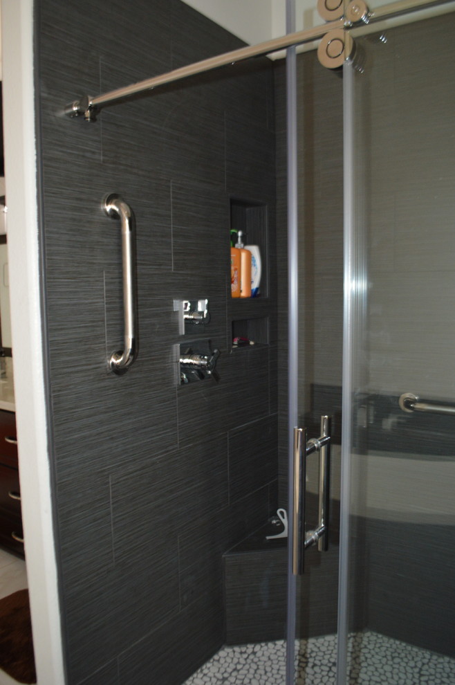 This is an example of a modern bathroom in Phoenix with shaker cabinets, white cabinets, an alcove shower, a two-piece toilet, black tile, pebble tile, grey walls, porcelain floors, an undermount sink, engineered quartz benchtops, grey floor, a sliding shower screen and multi-coloured benchtops.