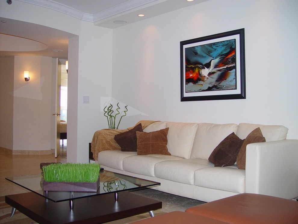 Photo of a small modern formal enclosed living room in Miami with white walls, marble floors and a concealed tv.