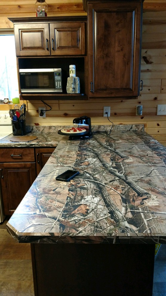 Small mountain style u-shaped medium tone wood floor and brown floor enclosed kitchen photo with a double-bowl sink, raised-panel cabinets, dark wood cabinets, laminate countertops, beige backsplash, wood backsplash, white appliances and a peninsula