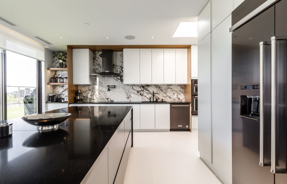 Esempio di una grande cucina moderna con ante lisce, top in granito, paraspruzzi in gres porcellanato, elettrodomestici in acciaio inossidabile, pavimento in cemento, pavimento bianco e top nero
