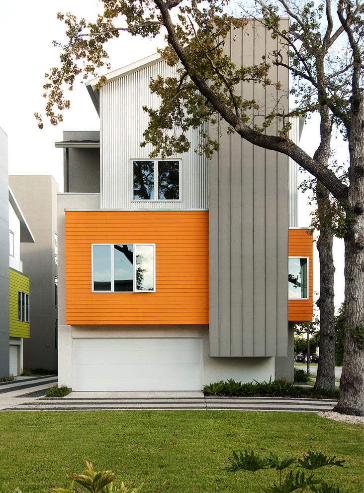 Inspiration for a contemporary three-storey orange exterior in Houston with mixed siding.