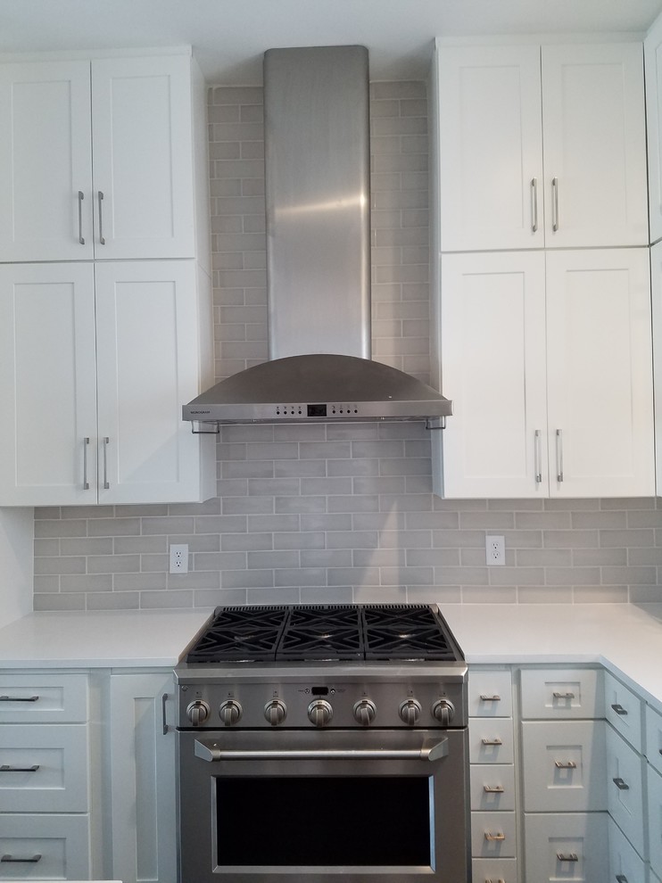 Mid-sized transitional open concept kitchen photo in Jacksonville with shaker cabinets, white cabinets, quartz countertops, gray backsplash, subway tile backsplash, stainless steel appliances and white countertops