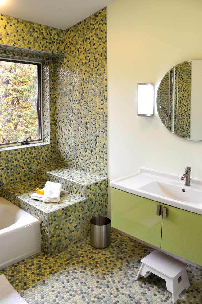 Photo of a contemporary bathroom in Other with a console sink, flat-panel cabinets, green cabinets, an alcove tub, multi-coloured tile, mosaic tile, yellow walls and mosaic tile floors.
