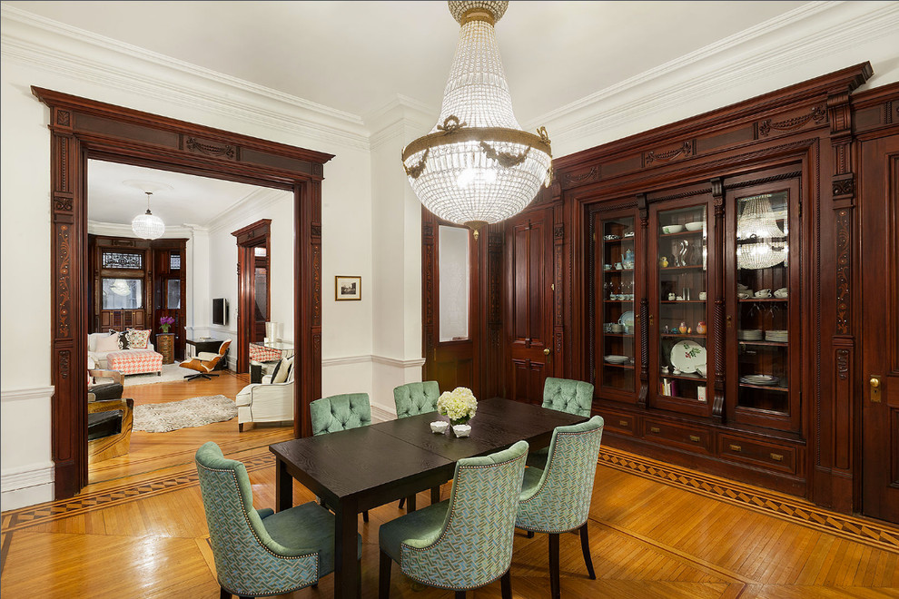 This is an example of a traditional separate dining room in New York with white walls and medium hardwood floors.