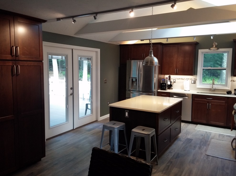 Eat-in kitchen - mid-sized transitional l-shaped medium tone wood floor and gray floor eat-in kitchen idea in Boston with a single-bowl sink, shaker cabinets, dark wood cabinets, quartz countertops, white backsplash, subway tile backsplash, stainless steel appliances, an island and beige countertops