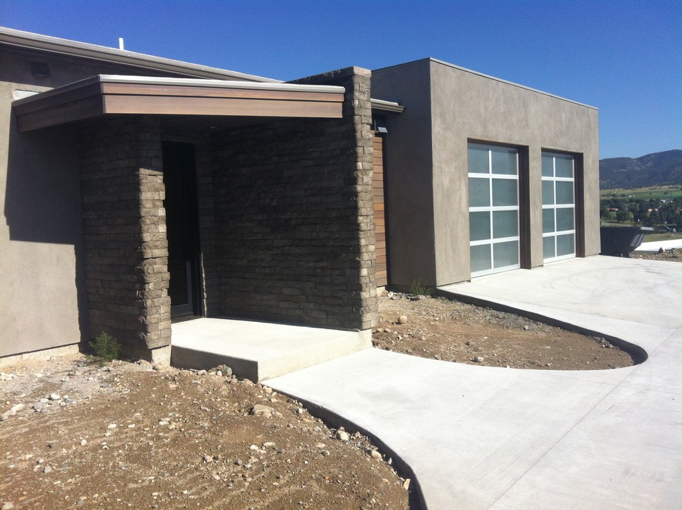 This is an example of a mid-sized contemporary one-storey stucco brown exterior in Denver.