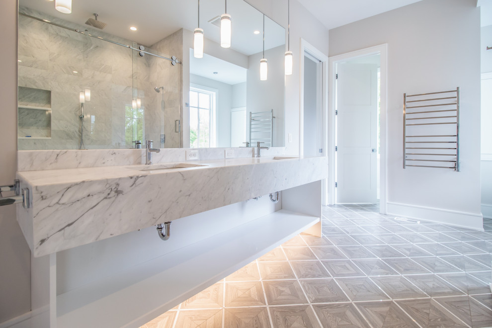 This is an example of an expansive modern master bathroom in Cleveland with open cabinets, a freestanding tub, a double shower, gray tile, grey walls, a sliding shower screen, multi-coloured benchtops, an enclosed toilet, a double vanity and a floating vanity.