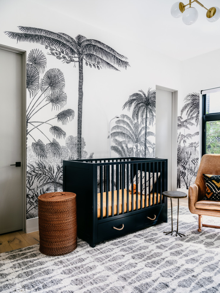 Réalisation d'une chambre de bébé neutre design de taille moyenne avec un mur multicolore, parquet clair et du papier peint.