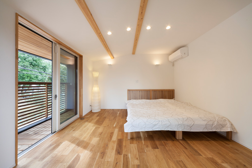 Foto de dormitorio escandinavo con paredes blancas, estufa de leña y suelo marrón