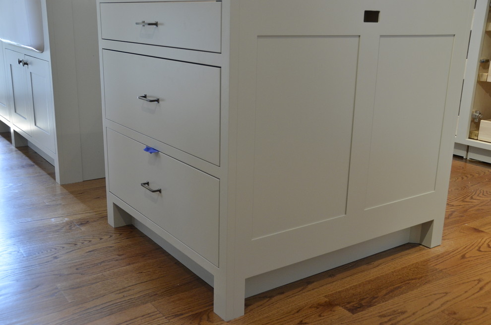 Inspiration for a transitional l-shaped kitchen remodel in New York with a farmhouse sink, shaker cabinets, gray cabinets, limestone countertops, gray backsplash, subway tile backsplash and stainless steel appliances