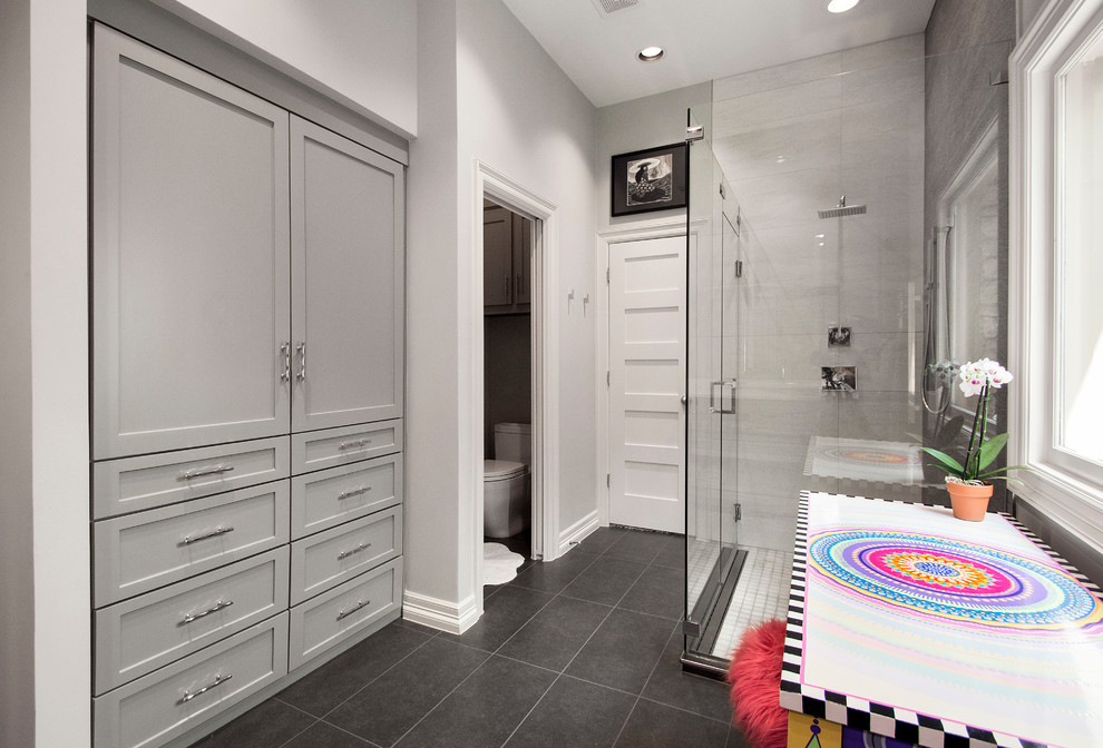 Photo of a mid-sized transitional master bathroom in Dallas with shaker cabinets, grey cabinets, a corner shower, a one-piece toilet, brown tile, porcelain tile, grey walls, porcelain floors, a vessel sink, engineered quartz benchtops, black floor and a hinged shower door.