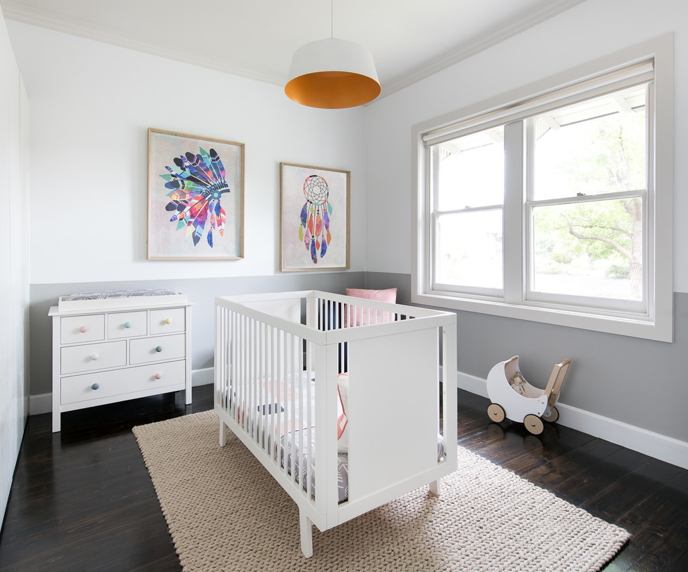 This is an example of a mid-sized transitional nursery for girls in Melbourne with multi-coloured walls, dark hardwood floors and brown floor.