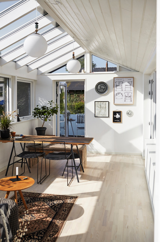 Photo of a small scandinavian sunroom in Wiltshire with light hardwood floors and a glass ceiling.