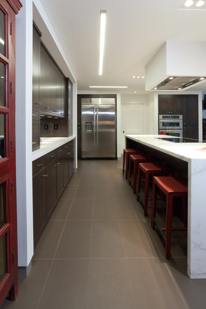 Photo of an expansive contemporary galley eat-in kitchen in Sacramento with an undermount sink, flat-panel cabinets, dark wood cabinets, marble benchtops, mirror splashback, stainless steel appliances and multiple islands.