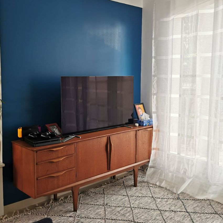 Пример оригинального дизайна: большая открытая гостиная комната в стиле фьюжн с синими стенами, мраморным полом, отдельно стоящим телевизором и белым полом без камина