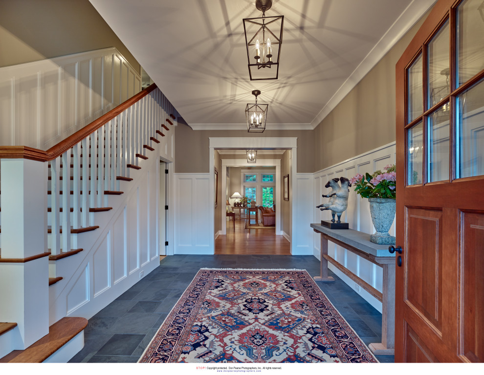 高級な中くらいなトランジショナルスタイルのおしゃれな玄関ロビー (緑の壁、スレートの床、木目調のドア、グレーの床) の写真