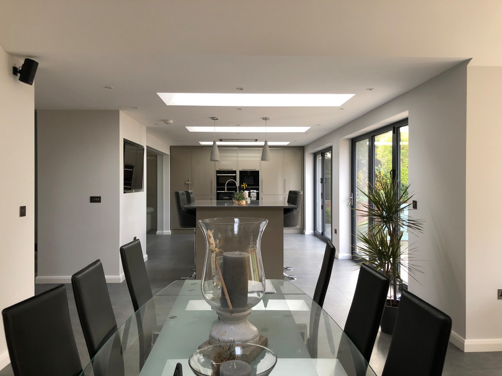 Photo of a medium sized modern open plan dining room in Other with yellow walls, porcelain flooring, grey floors and a vaulted ceiling.