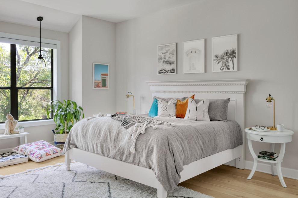 Großes Modernes Hauptschlafzimmer mit weißer Wandfarbe, hellem Holzboden und braunem Boden in Austin