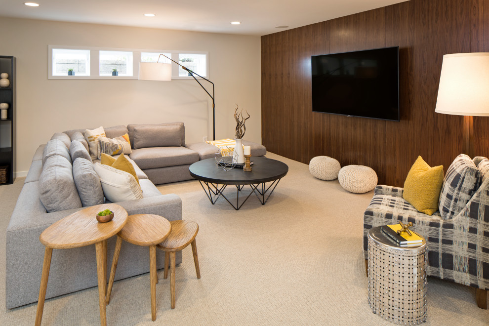 This is an example of a contemporary family room in Minneapolis with white walls, carpet, a wall-mounted tv, beige floor and wood walls.
