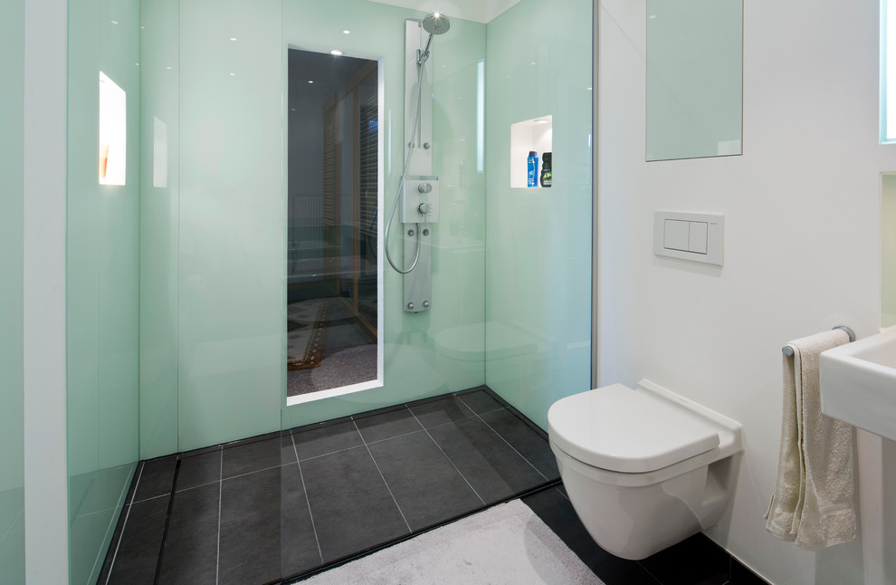 Badezimmer En Suite With flächenbündigen Schrankfronten, weißen Schränken, Einbaubadewanne, offener Dusche, Wandtoilette mit Spülkasten, grünen Fliesen, Fliesen aus Glasscheiben, weißer Wandfarbe, Marmorboden, Aufsatzwaschbecken and Granit-Waschbecken/Waschtisch in Hamburg
