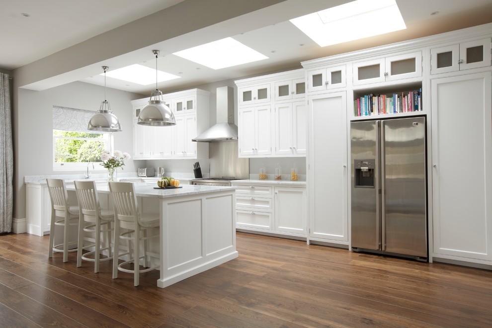 Design ideas for a large traditional l-shaped kitchen in London with shaker cabinets, white cabinets, stainless steel appliances, dark hardwood floors and with island.