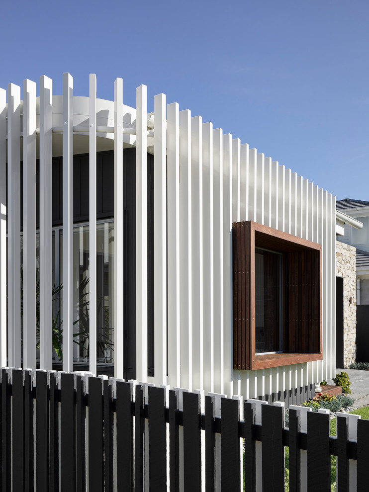 Mid-sized beach style two-storey white exterior in Brisbane with wood siding.