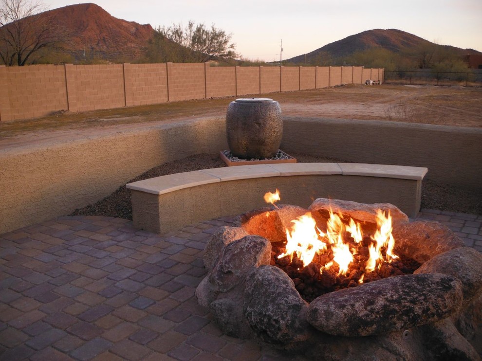 Design ideas for a mid-sized country backyard patio in Phoenix with a fire feature, brick pavers and no cover.