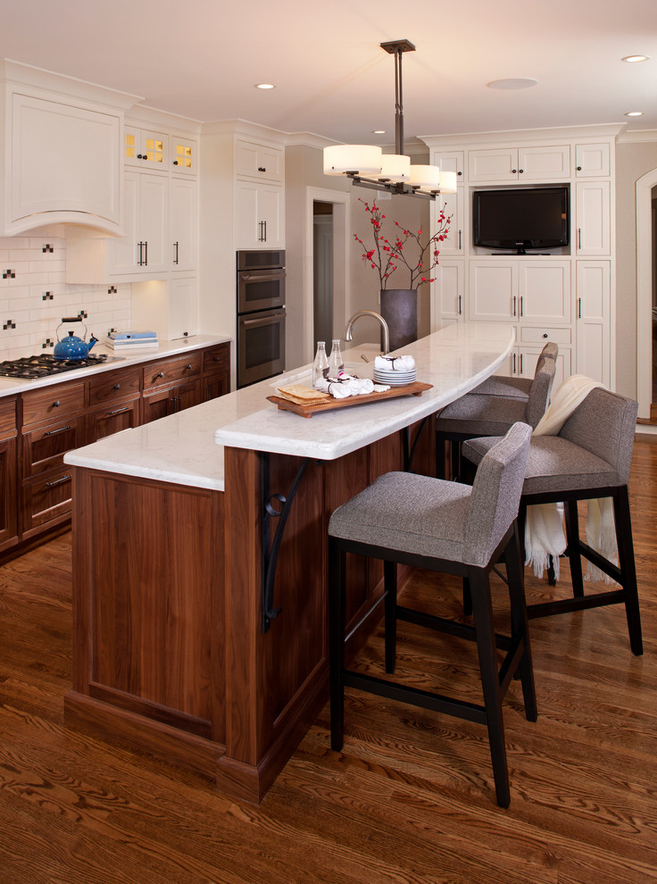 Inspiration for a mid-sized transitional galley kitchen in Minneapolis with beaded inset cabinets, beige cabinets, an undermount sink, quartz benchtops, white splashback, ceramic splashback, dark hardwood floors, with island and stainless steel appliances.